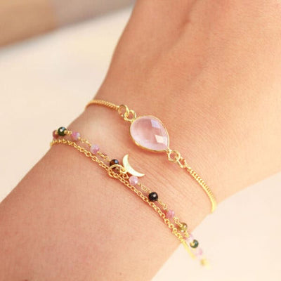 Detail van facetgeslepen rozenkwarts aan goudkleurige armband