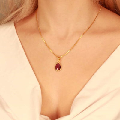 Detail van paarse amethist hanger aan goudkleurige ketting